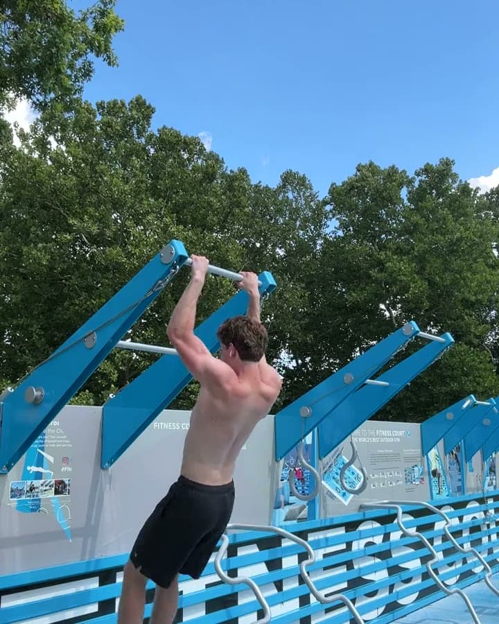 Athlete pulling explosively, chest rising toward the bar